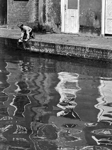 361179 Afbeelding van een jongen op de rand van de werf langs de Oudegracht te Utrecht.